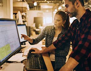 Business partners looking at spreadsheet on computer.