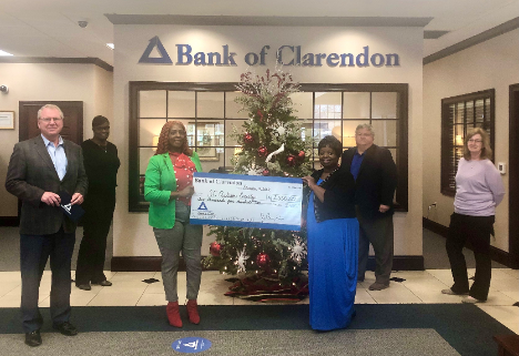 Two women receiving large donation check from Bank of Clarendon to SC Autism Society
