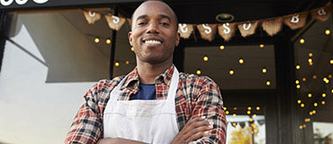 Business owner standing in front of his business.